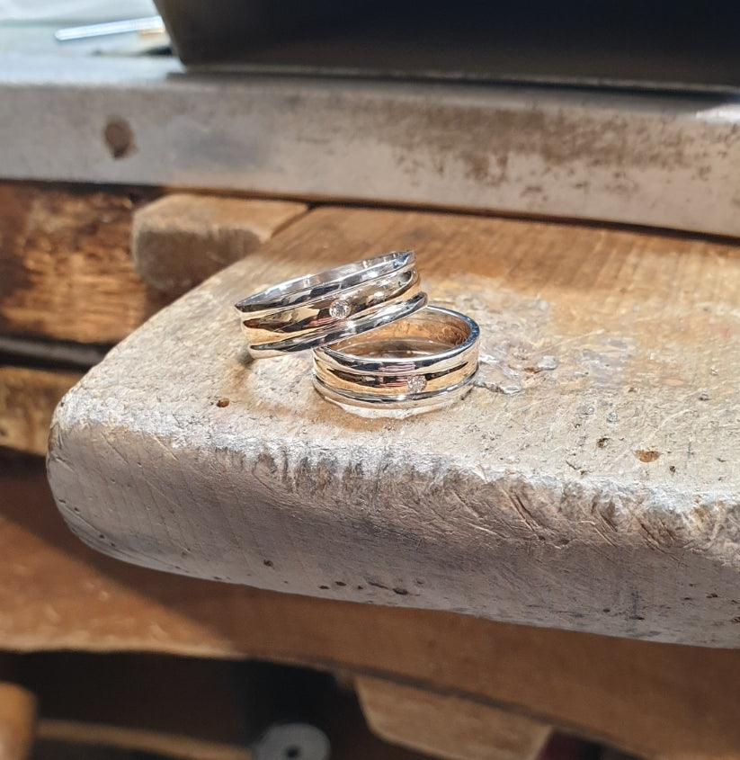 Fedi in oro giallo con creazione di un  bordino in oro bianco su entrambi i lati per 25° anniversario di matrimonio