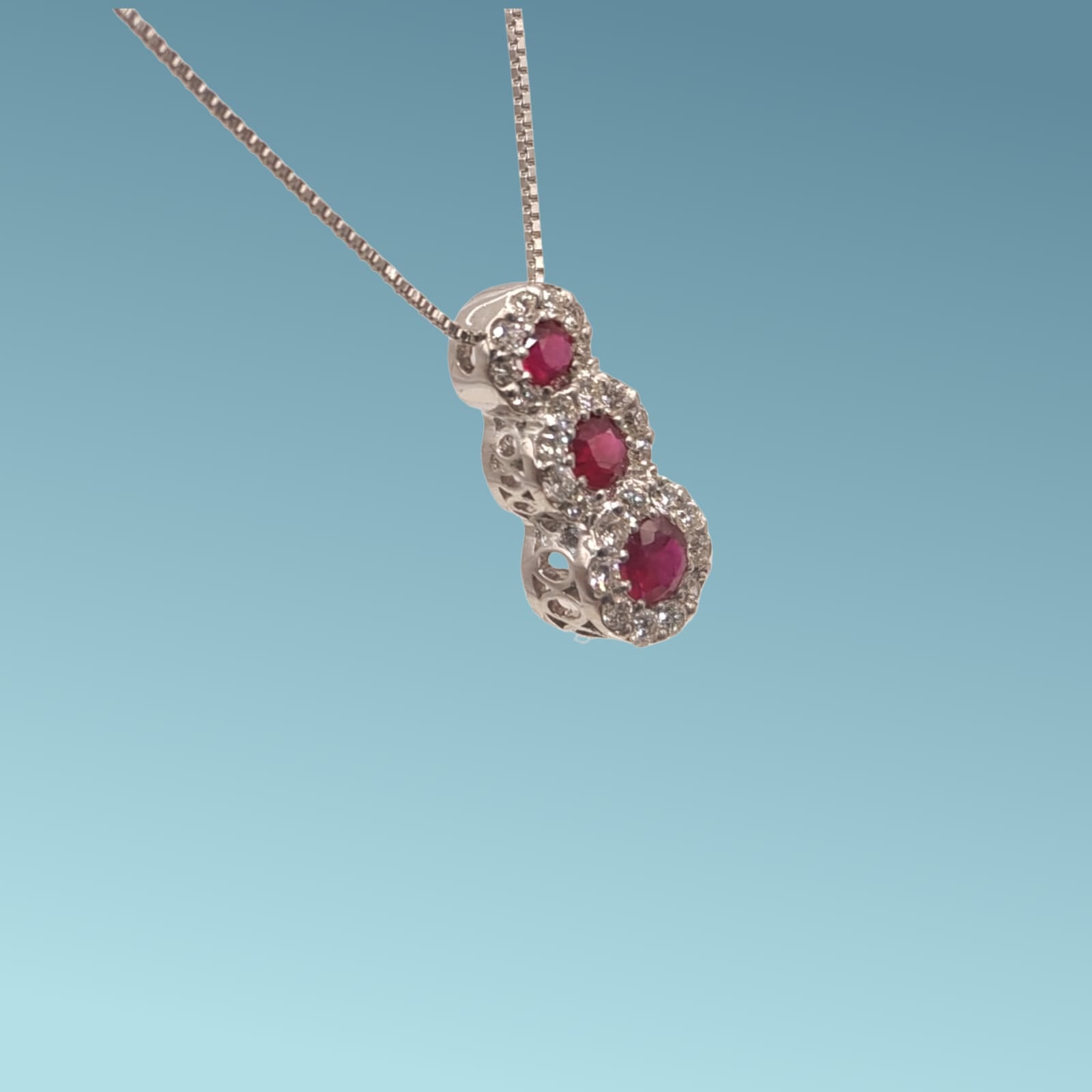 Girocollo in oro bianco 18kt di Meteore Gioielli presenta tre rubini naturali tondi circondati da una coroncina di diamanti naturali taglio brillante