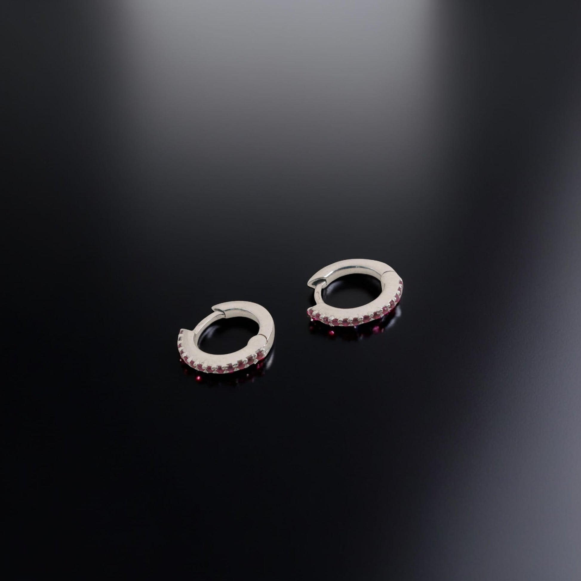 Orecchini in oro bianco 18kt di Meteore Gioielli a forma di cerchio diametro 11mm con una fila di rubini naturali taglio brillante per un totale di 0.16 ct