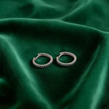 Orecchini in oro bianco 18kt di Meteore Gioielli a forma di cerchio diametro 16mm con una fila di smeraldi naturali taglio brillante incassati a griffes di 0.21ct