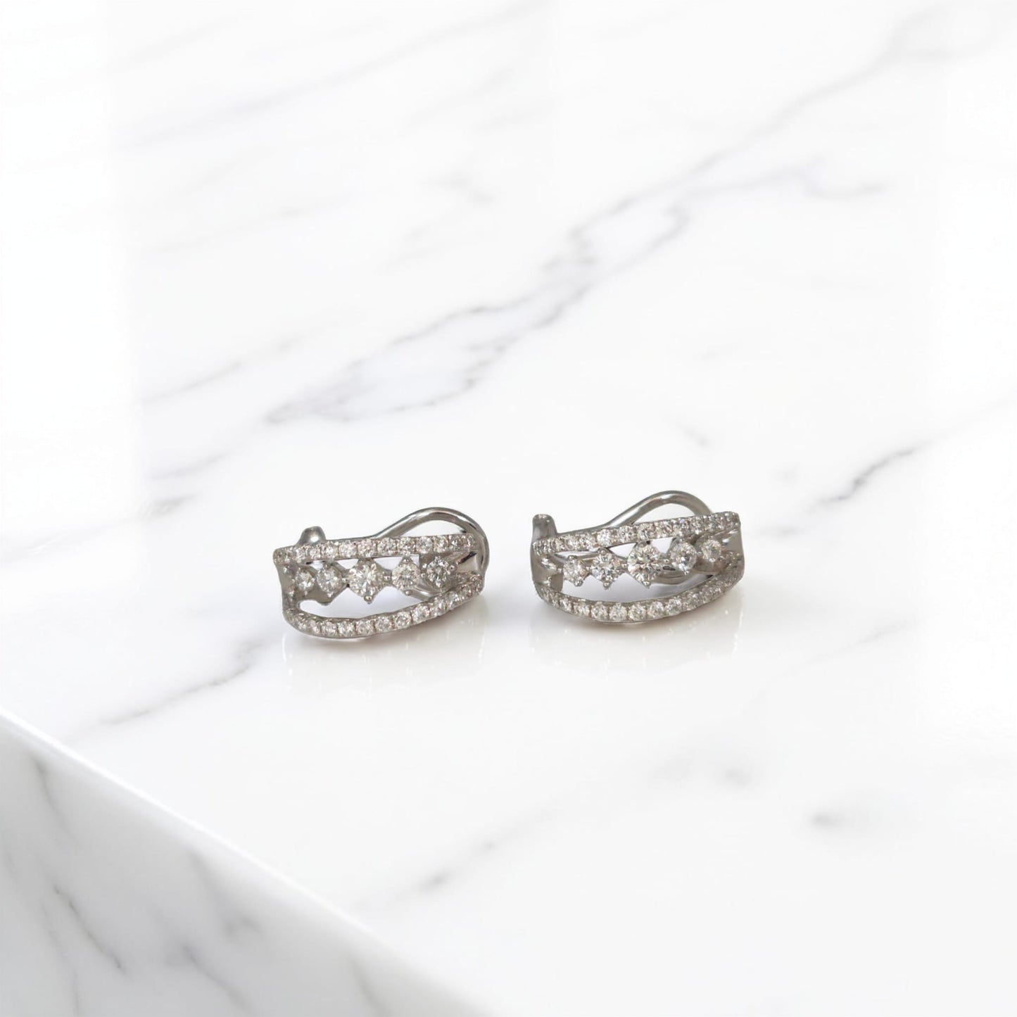 orecchini in oro bianco 18kt di meteore gioielli con diamanti naturali  su una montatura a semicerchio con chiusura a clips per un totale di 0.97 ct. 