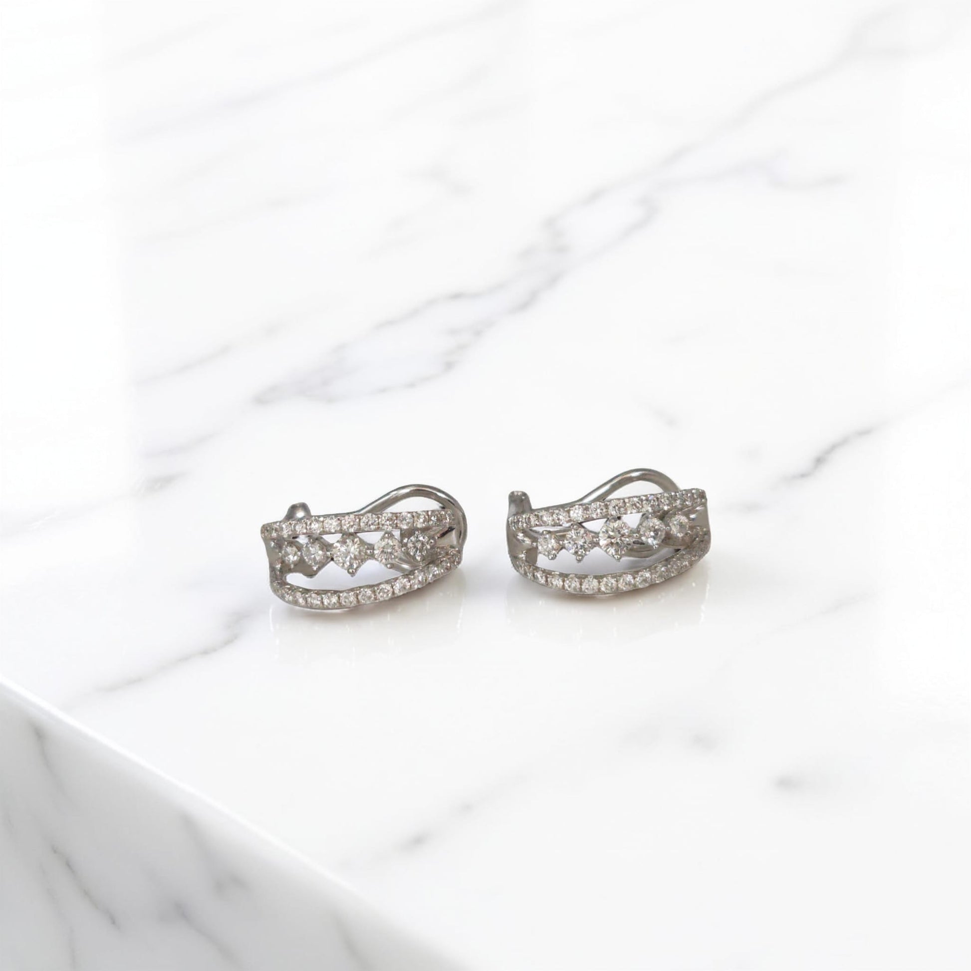 orecchini in oro bianco 18kt di Meteore Gioielli con diamanti naturali  su una montatura a semicerchio con chiusura a clips per un totale di 0.97 ct. 