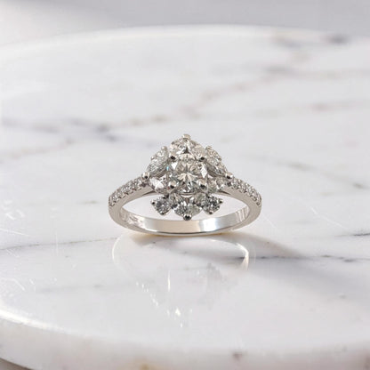 Anello in oro bianco 18Kt con diamante centrale taglio brillante da 0,51 ct, contornato da diamanti taglio brillante e marquise a forma floreale, firmato Meteore Gioielli.