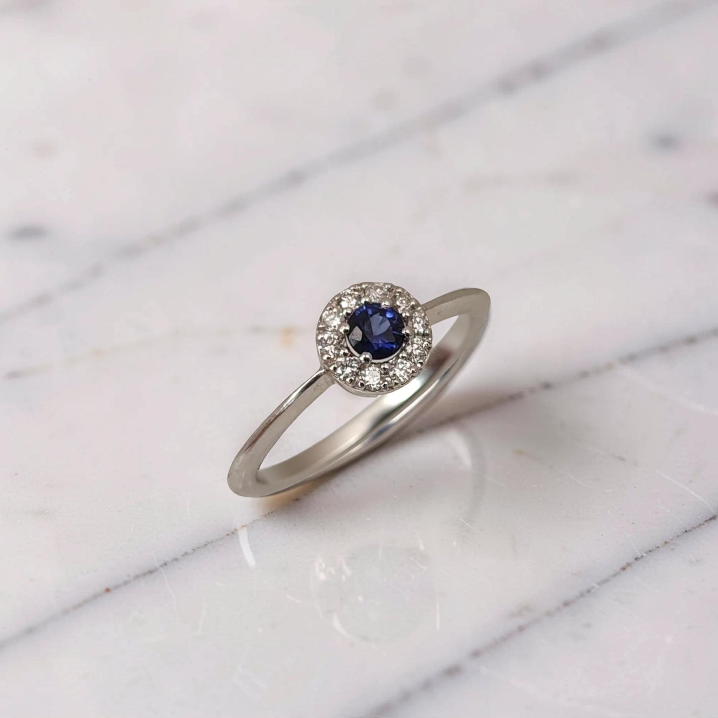 vista di profilo anello in oro bianco 18kt con zaffiro rotondo naturale blu e diamanti brillanti firmato meteore gioielli