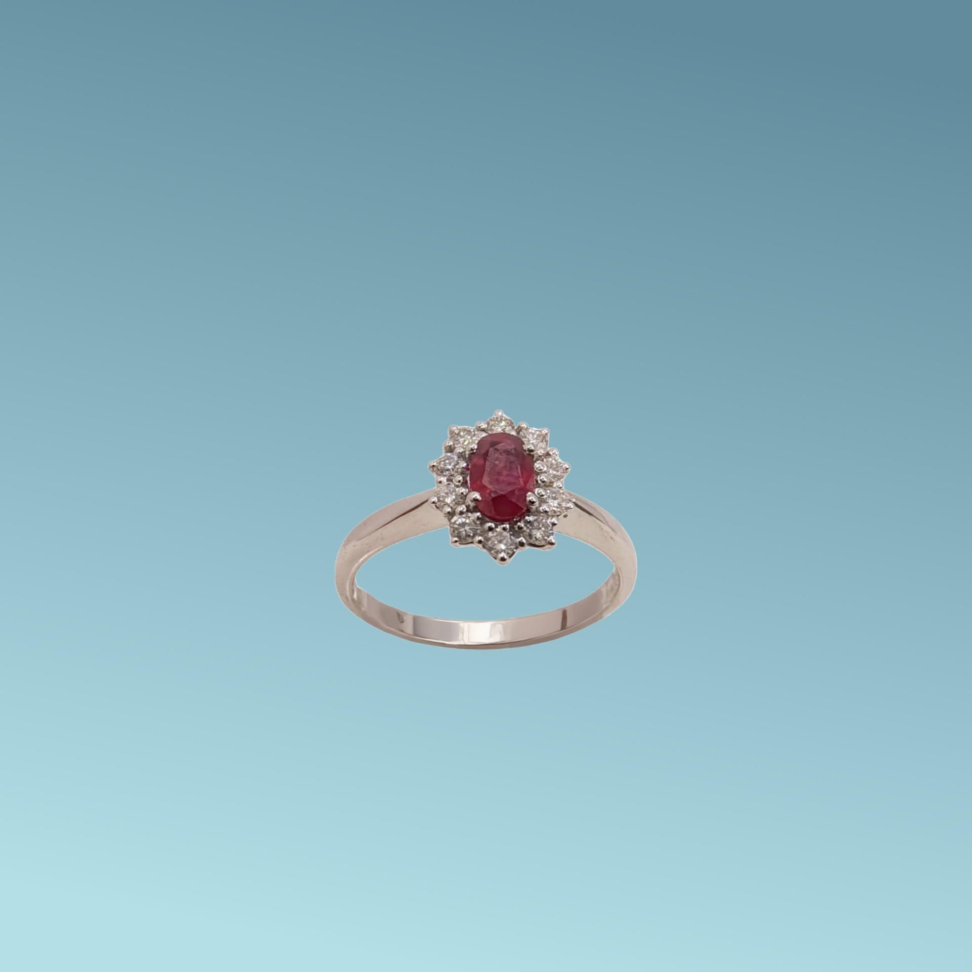 Anello in oro bianco 18kt di Meteore Gioielli con Rubino naturale taglio ovale ct 0.53 contornato da diamanti naturali taglio brillante ct 0.31.