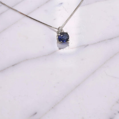 Collana in oro bianco 18 KT con zaffiro naturale ovale orizzontale da 0,36 ct e tre diamanti incastonati a triangolo  visto in prospettiva laterale firmata Meteore Gioielli