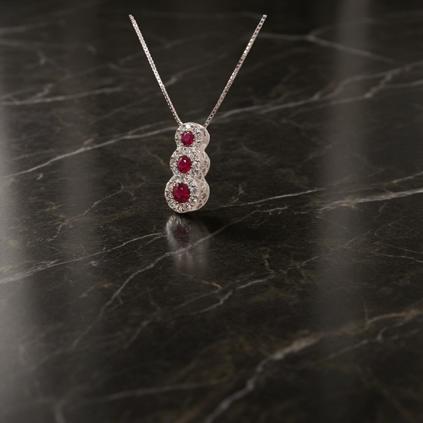 collana trilogy in oro bianco 18kt di meteore gioielli con tre rubini tondi naturali ct0.34 montati a scalare circondati da diamanti naturali  0.22ct .