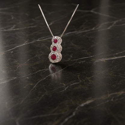 Collana trilogy in oro bianco 18kt di Meteore Gioielli con tre rubini tondi naturali ct0.34 montati a scalare circondati da diamanti naturali  0.22ct .