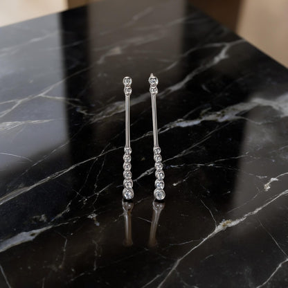 Dettaglio in primo piano Orecchini in oro bianco 18kt di Meteore Gioielli presentano una cascata di diamanti naturali taglio brillante per un totale di 0.15ct 
