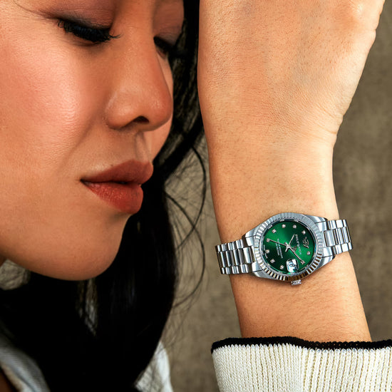 Orologio da donna con movimento al quarzo ETA F04.115 e funzioni di solo tempo con data.
Cassa in acciaio inox dal diametro di 28 mm. Lunetta zigrinata.
Fondello a vite per garantire maggiore impermeabilità.
Quadrante analogico verde con diamanti agli indici, logo a ore 12 e datario a ore 3 con lente di ingrandimento.
Vetro zaffiro.
Cinturino in acciaio anallergico; chiusura deployante con pulsanti.
Resistente all'acqua fino a 100 metri di profondità.
Appartiene alla collezione Caribe Urban.