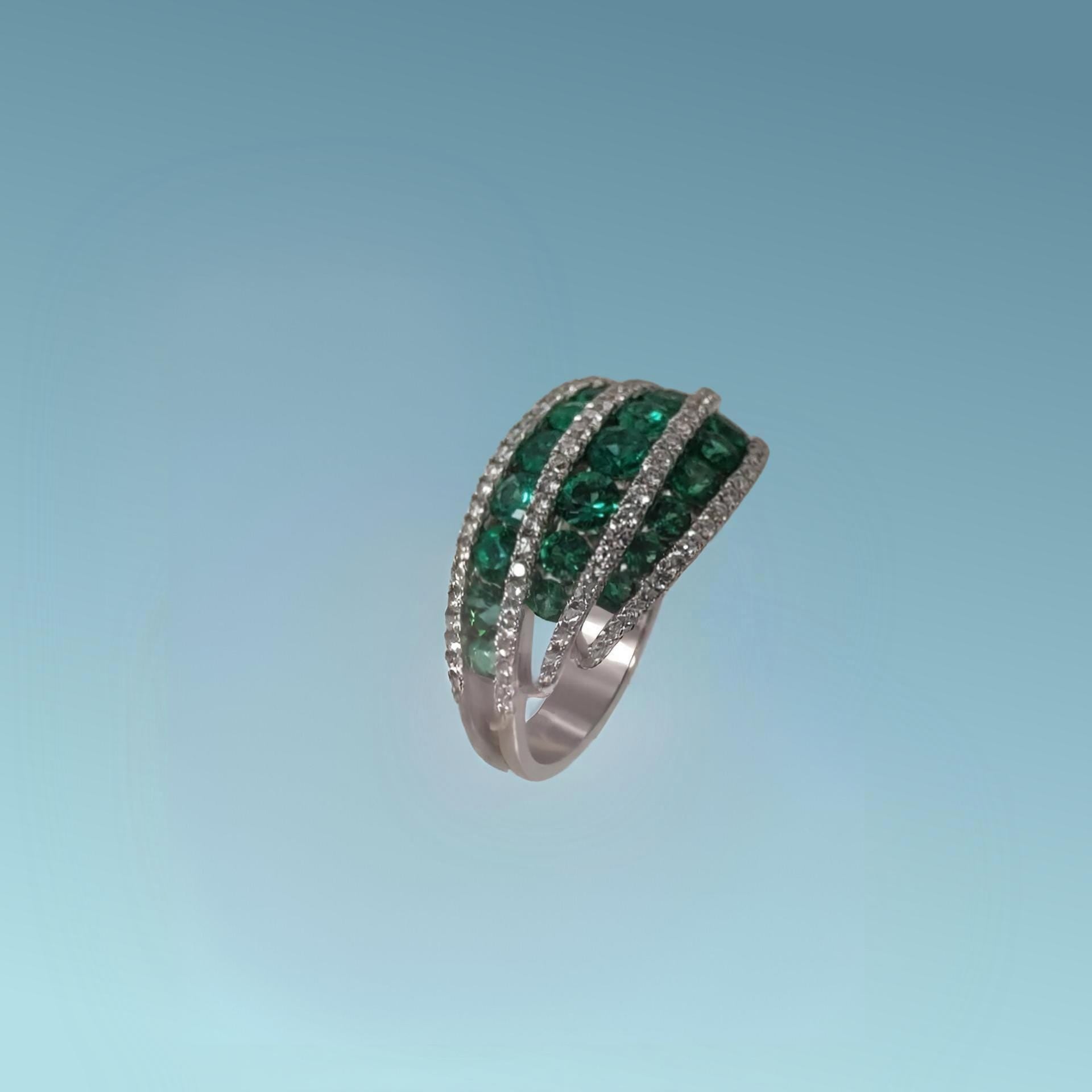 Meraviglioso anello di meteore Gioielli presenta un design a tre file armoniose di smeraldi naturali taglio brillante per un totale di 1.30 carati, incorniciate da quattro file di scintillanti diamanti naturali taglio brillante per un totale di 0.51 carati