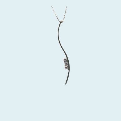 Collana con Pendente a forma di S con incassati al lato tre diamanti naturali taglio brillante, le sue forme sinuose e morbide, trasmettono un senso di dolcezza e eleganza.