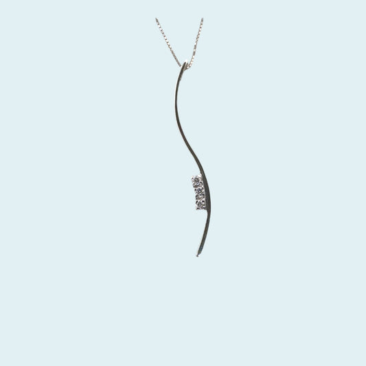 Collana con Pendente a forma di S con incassati al lato tre diamanti naturali taglio brillante, le sue forme sinuose e morbide, trasmettono un senso di dolcezza e eleganza.
