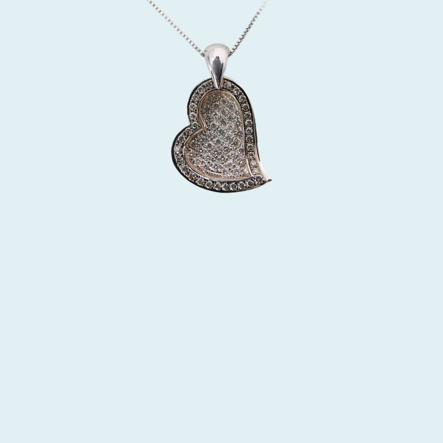 due cuori  sovrapposti, quello superiore in oro rosa incassato con diamanti fancy brown che fa da cornice a quello inferiore in oro bianco con pavè di diamanti.