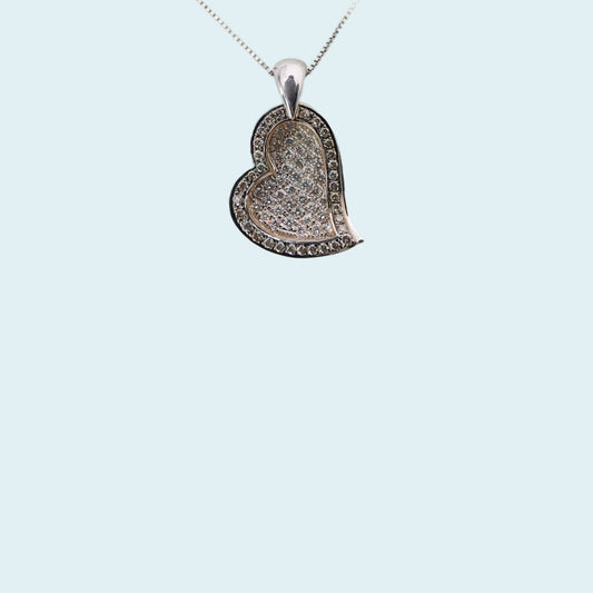 Due cuori  sovrapposti, quello superiore in oro rosa incassato con diamanti fancy brown che fa da cornice a quello inferiore in oro bianco con pavè di diamanti.
