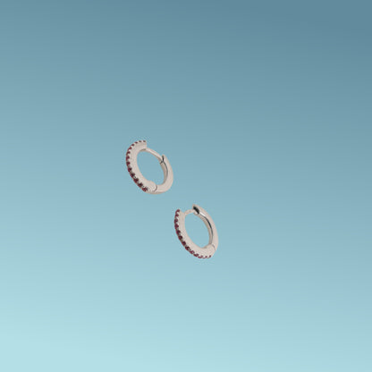 Orecchini in oro bianco 18kt di Meteore Gioielli a forma di cerchio diametro 11mm con una fila di rubini naturali taglio brillante per un totale di 0.16 ct