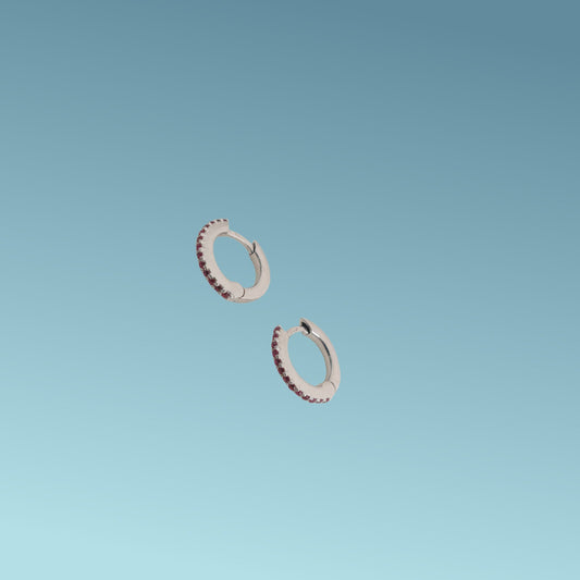 Orecchini in oro bianco 18kt di Meteore Gioielli a forma di cerchio diametro 11mm con una fila di rubini naturali taglio brillante per un totale di 0.16 ct