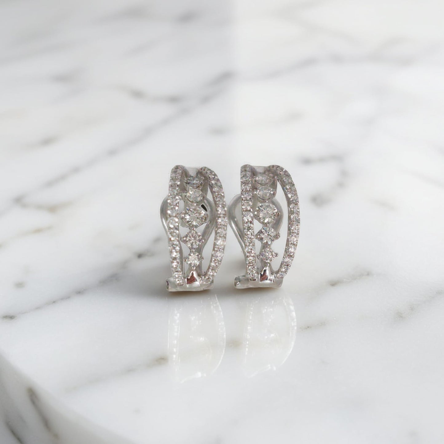 orecchini in oro bianco 18kt di meteore gioielli con diamanti naturali  su una montatura a semicerchio con chiusura a clips per un totale di 0.97 ct. 