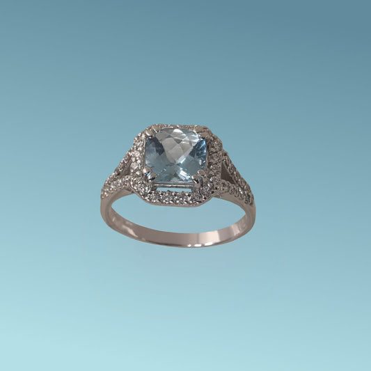 Anello in oro bianco 18kt di Meteore Gioielli presenta al centro una Acquamarina naturale dal taglio cuscino di ct 1.29 e un giro di diamanti naturali 0.50 ct 