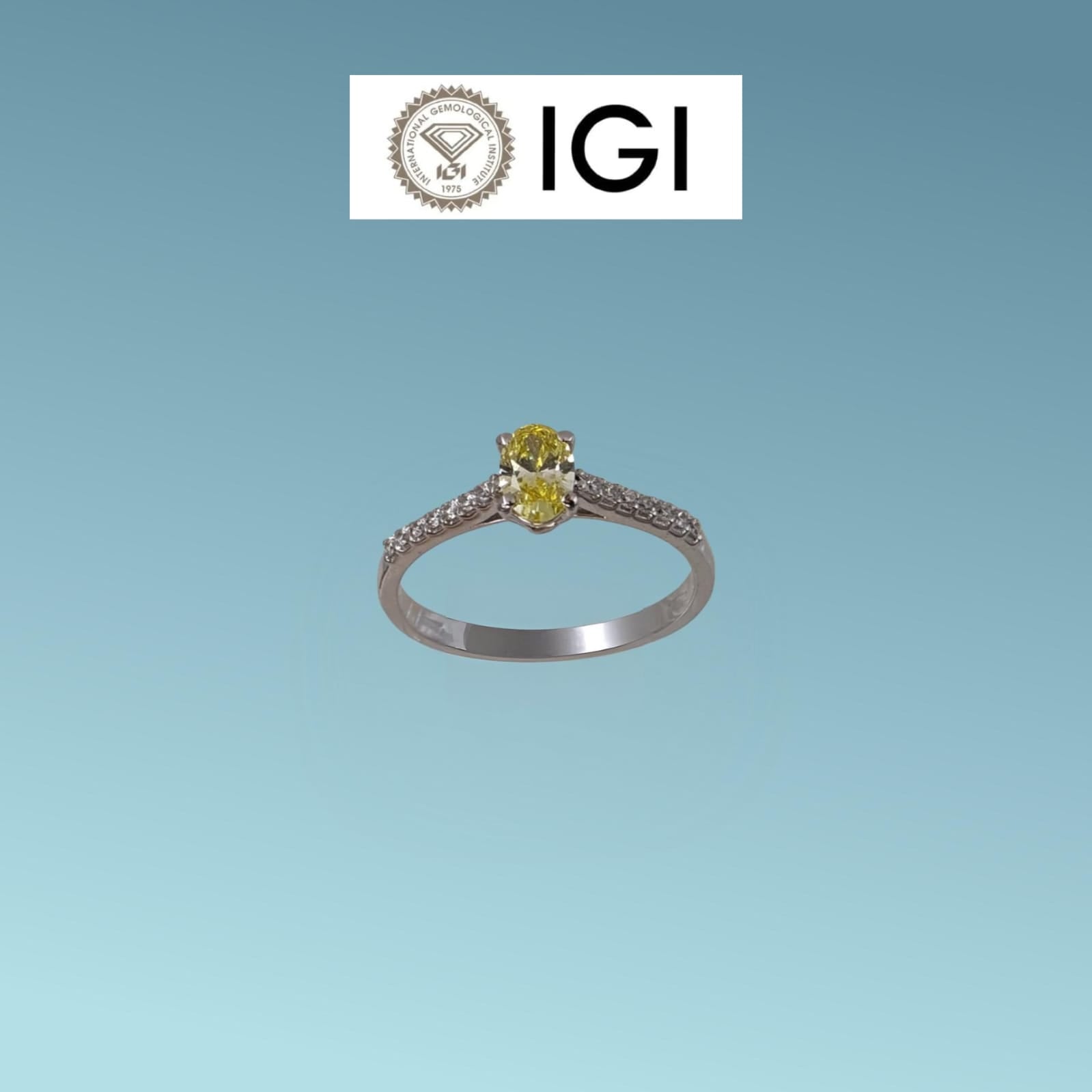 Anello in oro bianco 18kt di Meteore Gioielli con Diamante di Laboratorio Fancy Vivid Yellow ct 0.40 dal taglio ovale, sul gambo sono incassati ai due lati una fila di luminosissimi diamanti di laboratorio bianchi per un totale di 0.13 ct D/VS. 