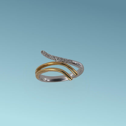 L'anello in oro bianco e giallo 18kt di Meteore Gioielli presenta tre linee ondulate che si incontrano al centro con diamanti naturali taglio brillante ct 0.05