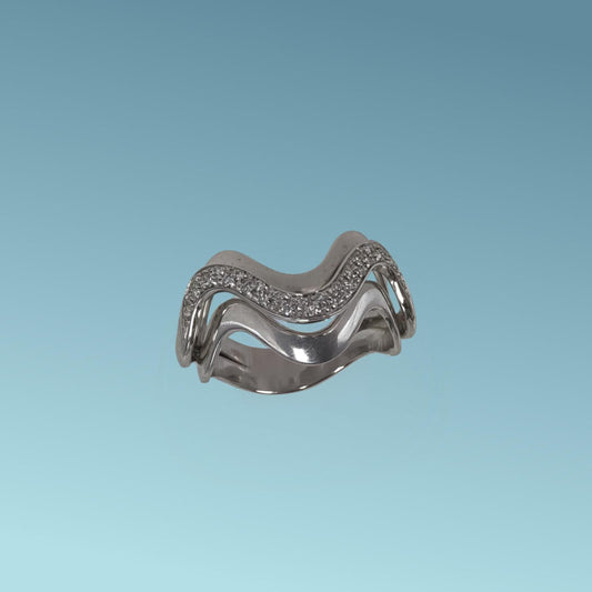 Anello Pavé in oro bianco 18kt di Meteore Gioielli è un gioiello dal design audace ed elegante, ispirato al movimento sinuoso delle onde, con diamanti ct 0.17