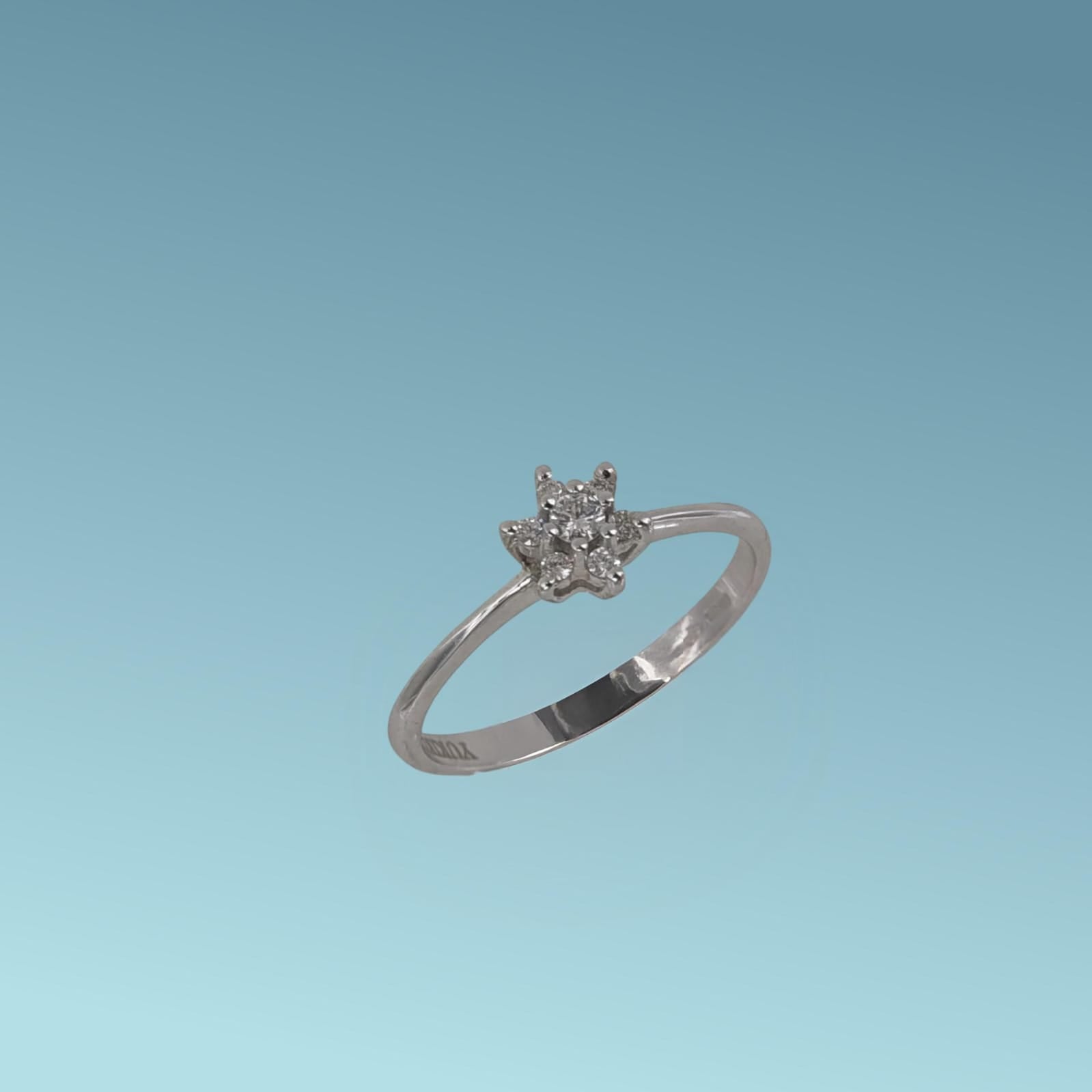 Anello fantasia in oro bianco 18kt di Meteore Gioielli presenta al centro un diamante naturale  e intorno sei diamanti più piccoli per un totale di 0.11ct.