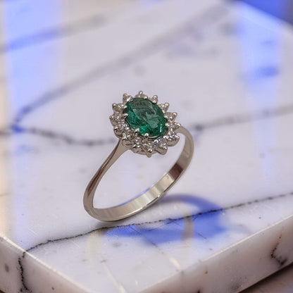 Anello in oro 18 kt con smeraldo naturale da 0,58 carati e contorno di diamanti taglio brillante da 0,23 carati totali. Dettagli.