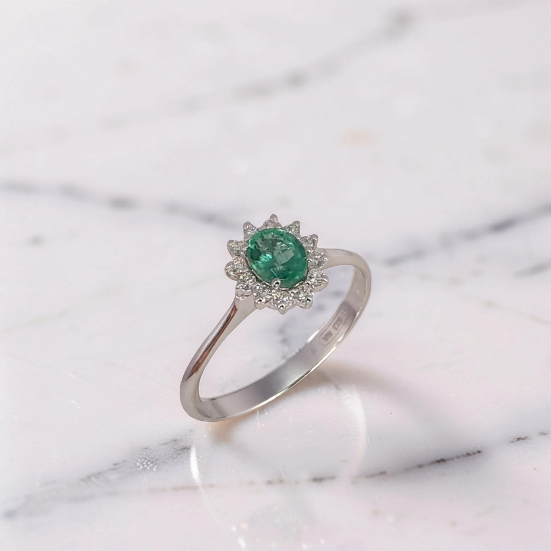 Anello in oro bianco 18kt, smeraldo naturale 0,36 ct dal taglio più profondo e dimensioni contenute, diamanti 0,11 ct G/VS1 a contorno.