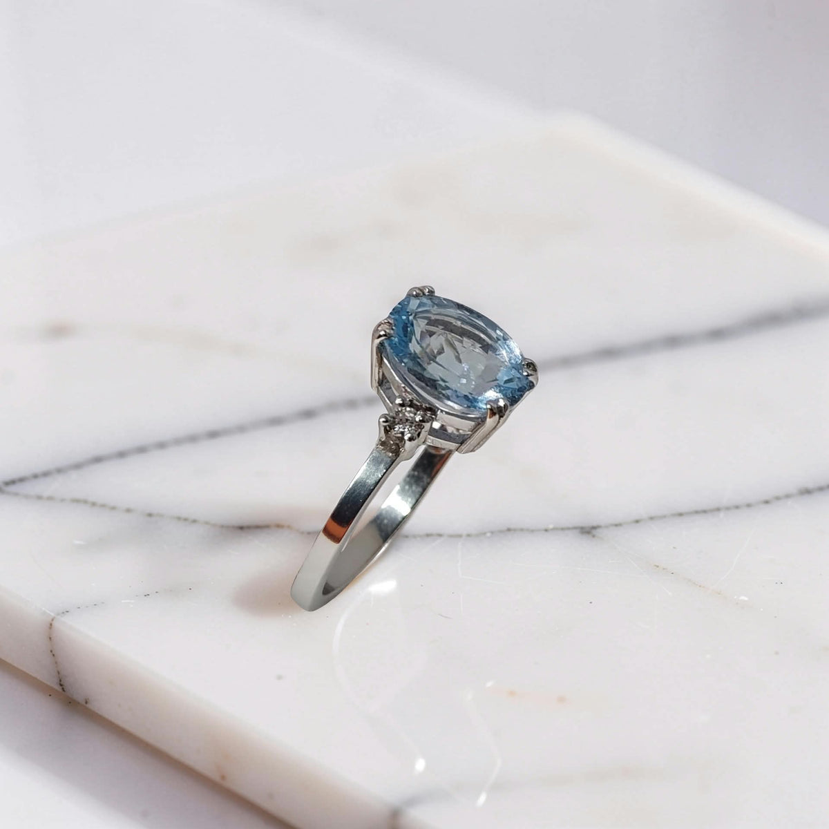 Anello con acquamarina ovale 1.60 carati e 2 diamanti ai lati della pietra, in oro bianco 18kt, vista di profilo