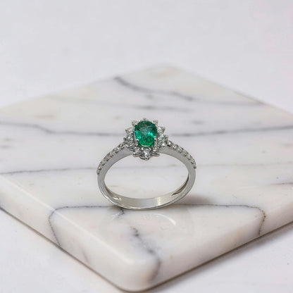 Anello oro bianco 18kt con smeraldo naturale ovale 0,45 ct e halo di diamanti e diamanti sul gambo