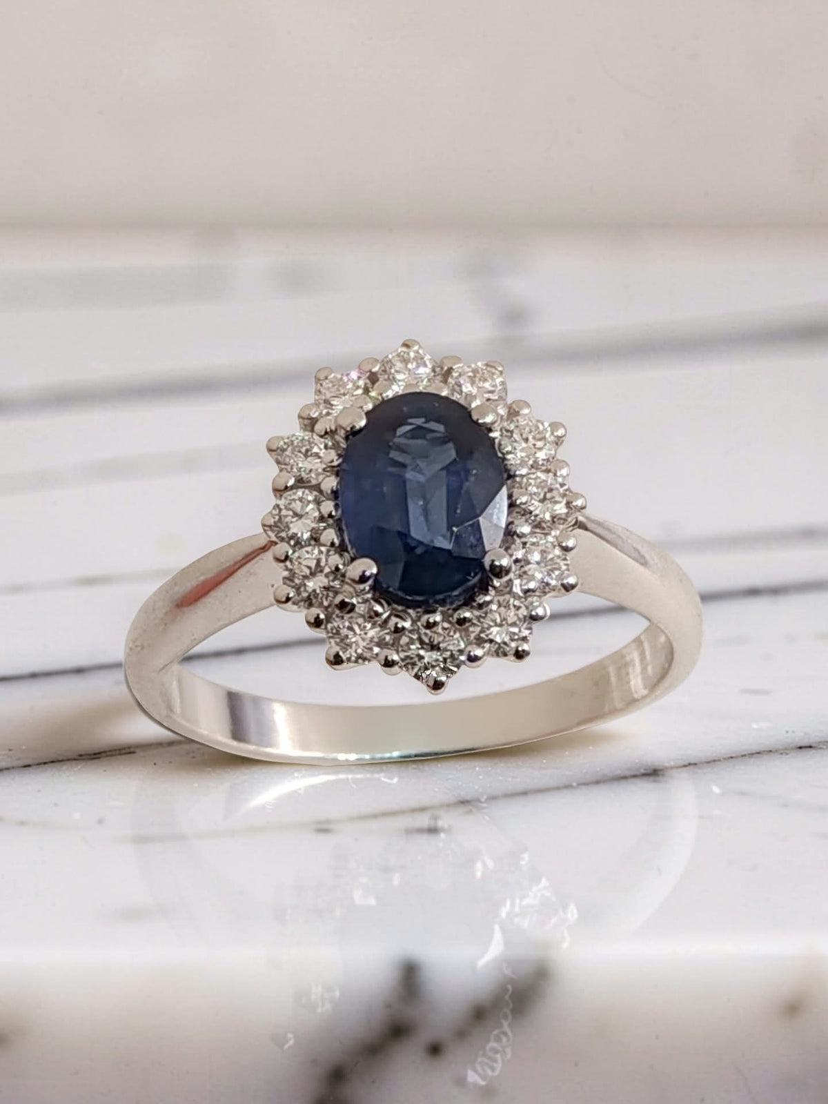 anello oro bianco 18kt con zaffiro blu naturale ovale 1,04 ct e halo di 12 diamanti, vista frontale