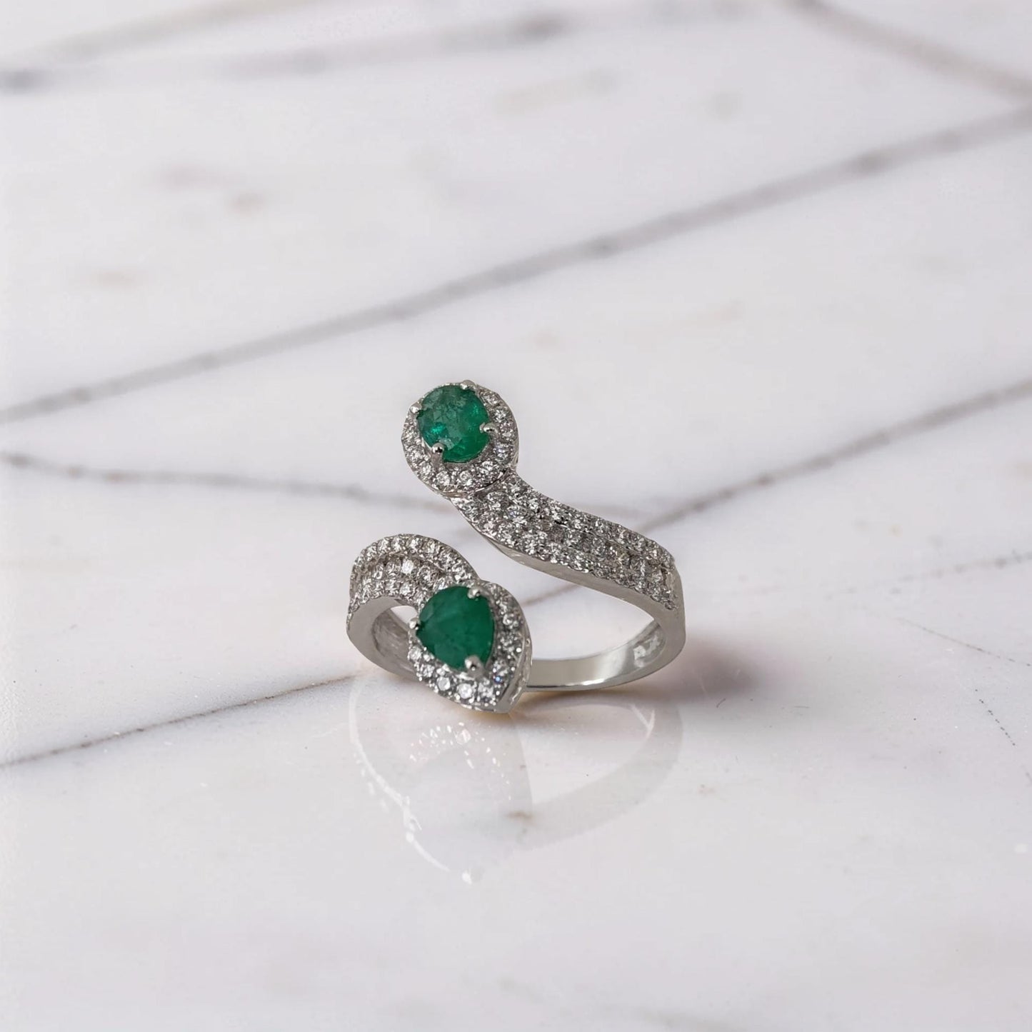 anello di lusso in oro bianco 18 carati con smeraldi verdi naturali e diamanti brillanti.