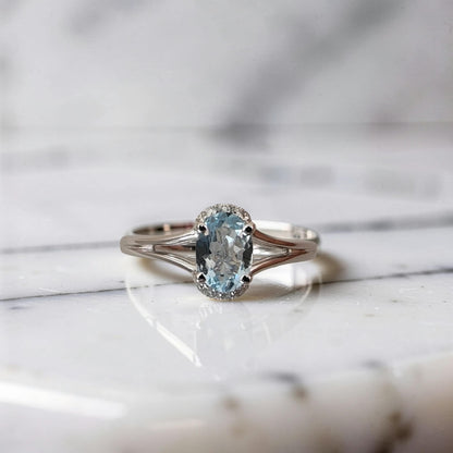 Vista frontale Anello in oro bianco 18 kt con acquamarina ovale 0.69 ct e 8 punti di diamanti sui lati corti. Design Meteore Gioielli.