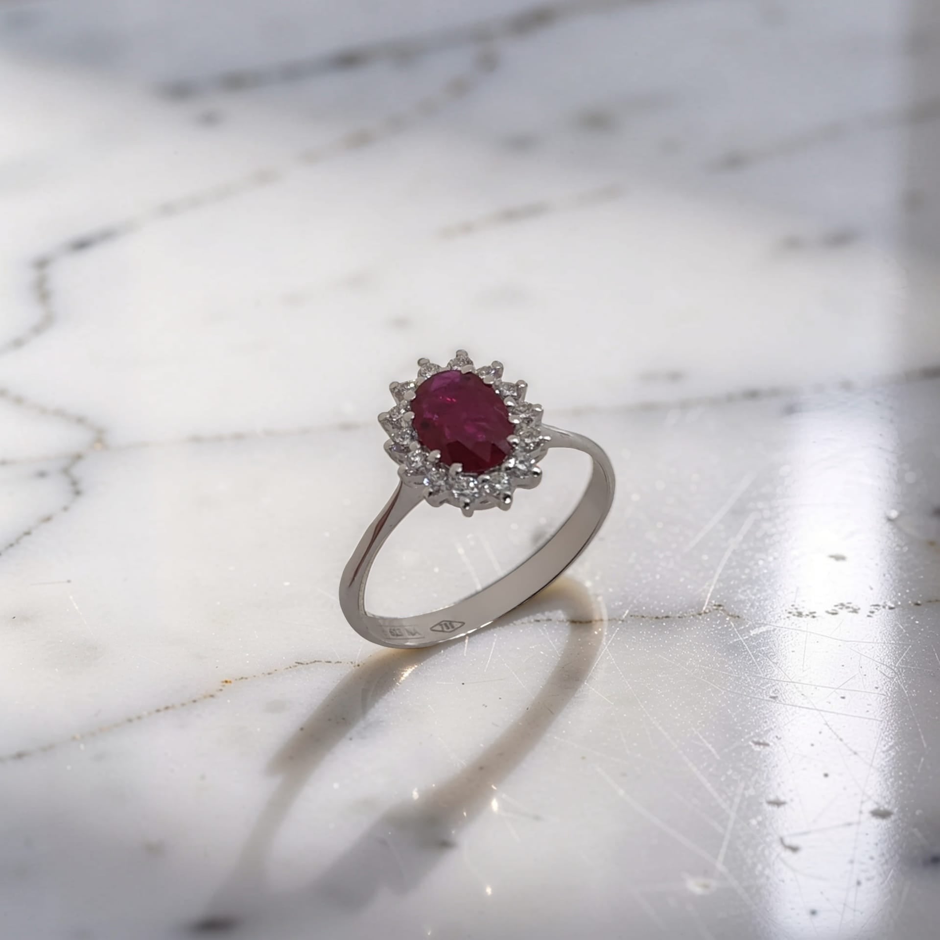 Dettaglio Anello in oro 18 kt con rubino ovale 0,65 ct e contorno di diamanti 0,23 ct. Scopri l'eleganza Meteore Gioielli