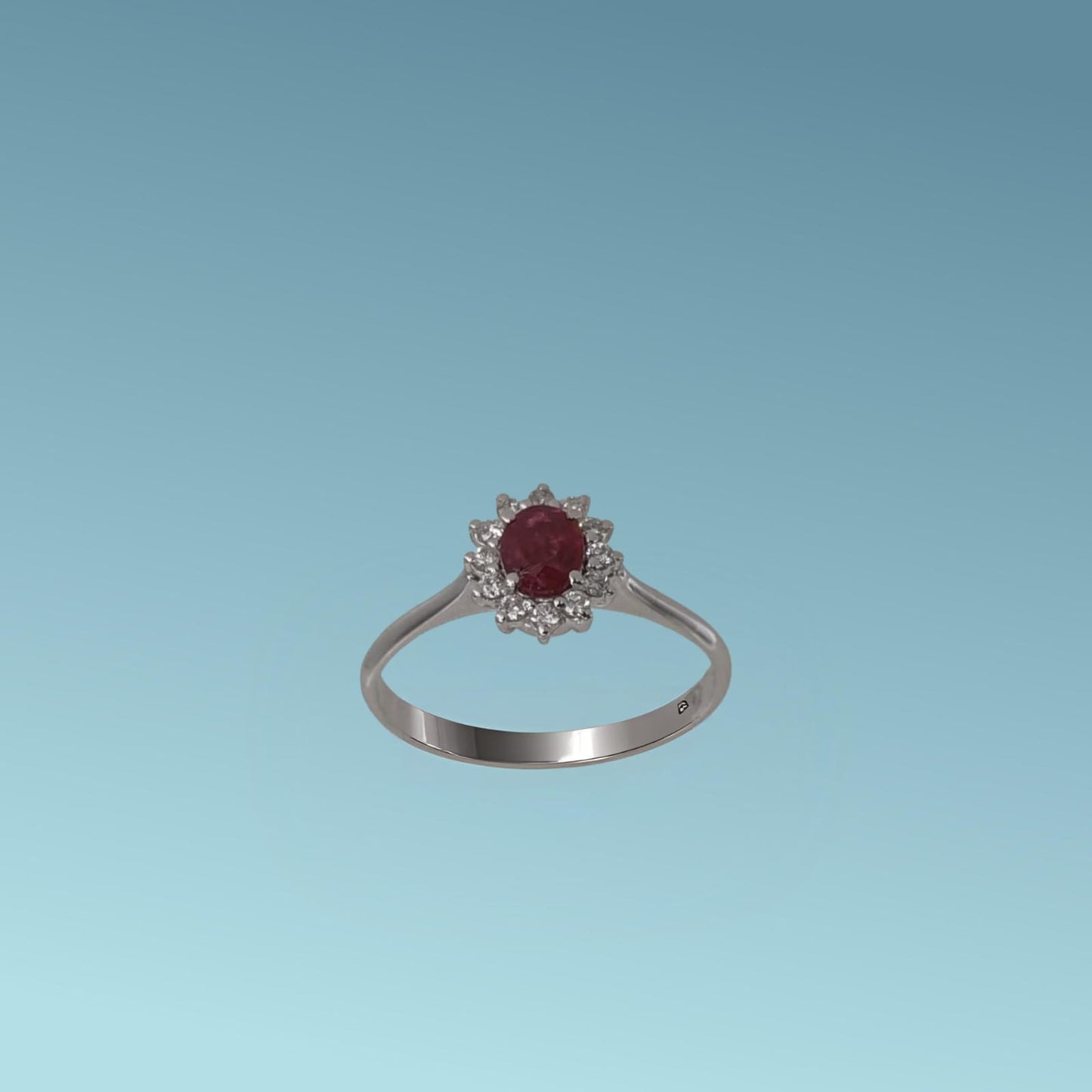 anello con rubino di meteore gioielli è realizzato oro bianco 18k,  presenta al centro un rubino naturale da 0.35 carati taglio ovale, incorniciato da una fila di diamanti naturali naturali taglio brillante ct 0.12.