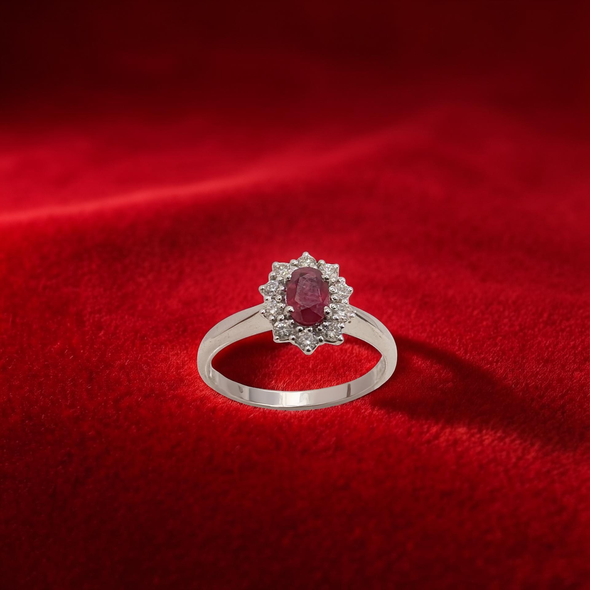 Anello in oro bianco 18kt di Meteore Gioielli con Rubino naturale taglio ovale ct 0.53 contornato da diamanti naturali taglio brillante ct 0.31.
