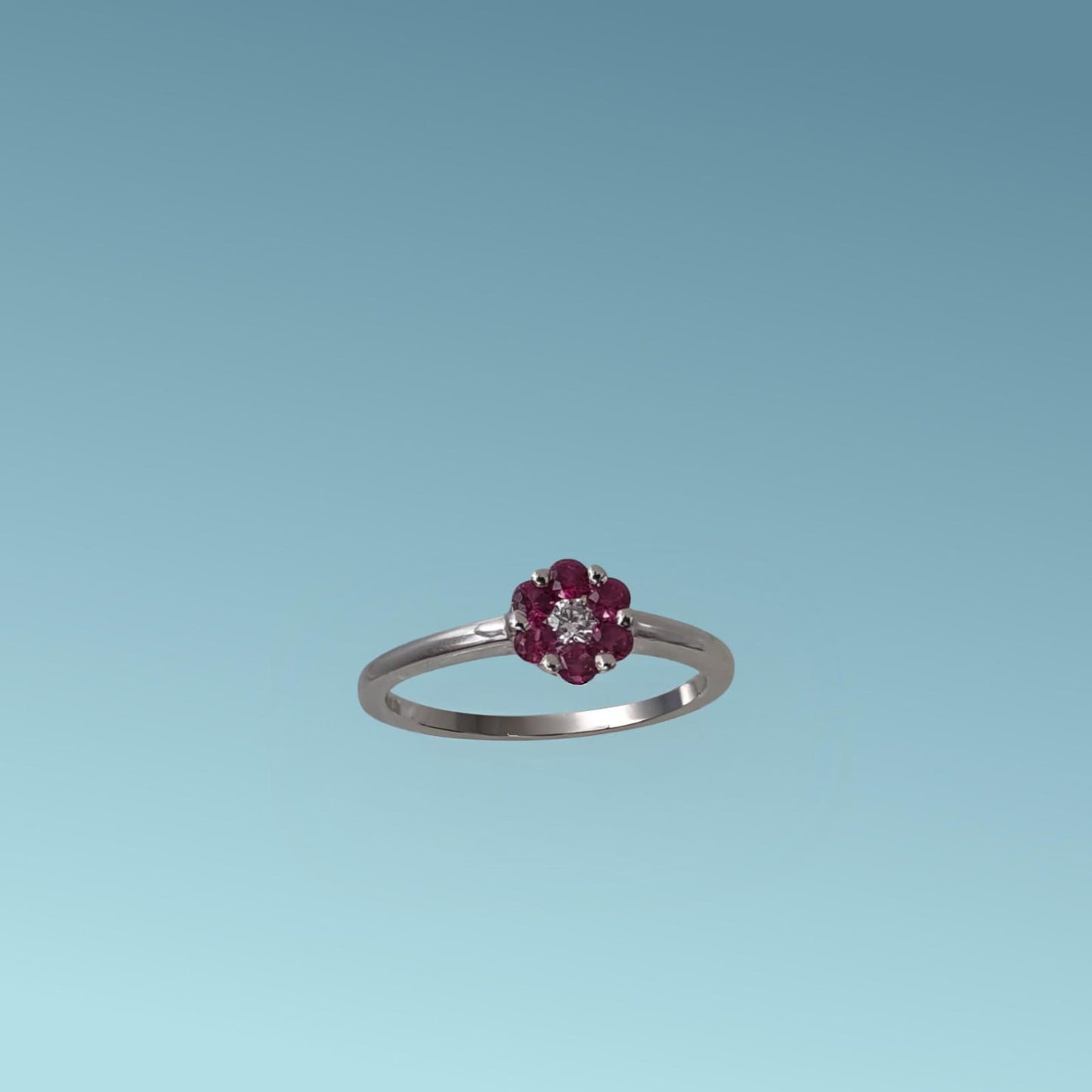 anello con rubino di meteore gioielli, realizzato in oro bianco 18k, presenta al centro un diamante naturale ct 0.05 incorniciato da 6 rubini naturali ct 0.30