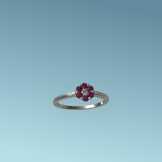 Anello con Rubino di Meteore Gioielli, realizzato in Oro Bianco 18k, presenta al centro un diamante naturale ct 0.05 incorniciato da 6 rubini naturali ct 0.30