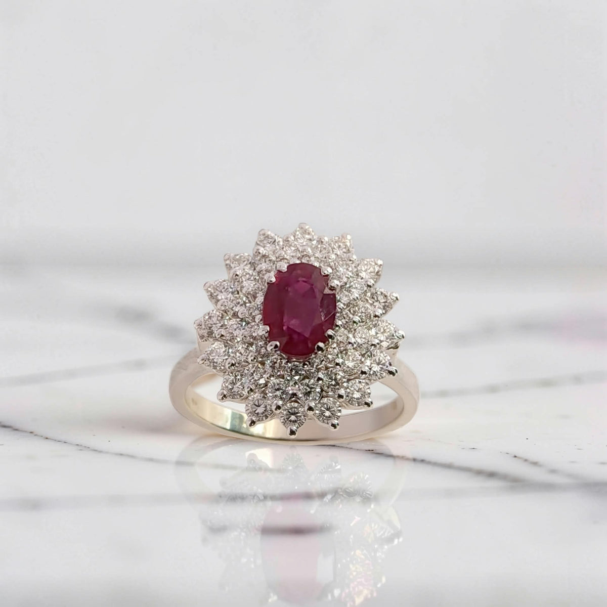 dettaglio del rubino ovale 0,88 ct circondato da tre giri di diamanti g vs1