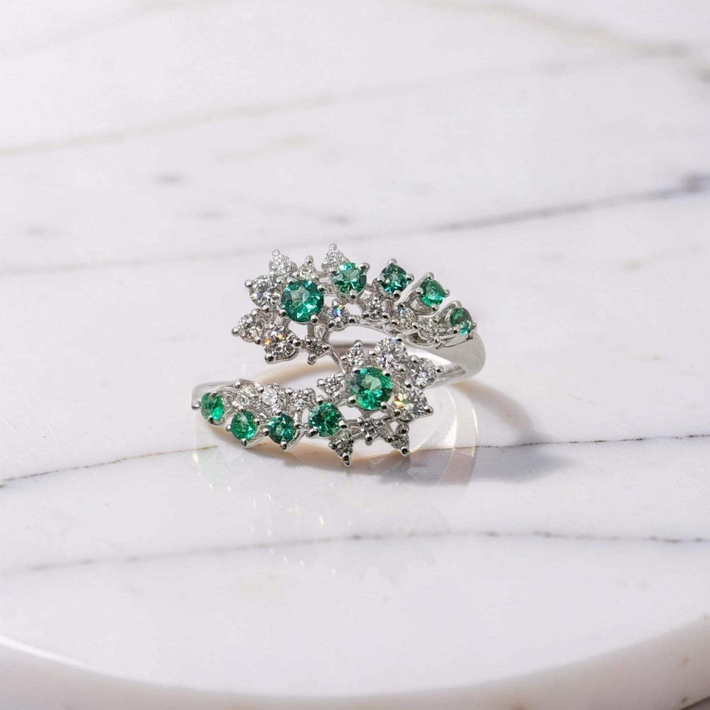 anello oro bianco 18kt meteore gioielli a due teste di serpente con smeraldi naturali e diamanti naturali 0,39 ct su sfondo bianco marmoreo