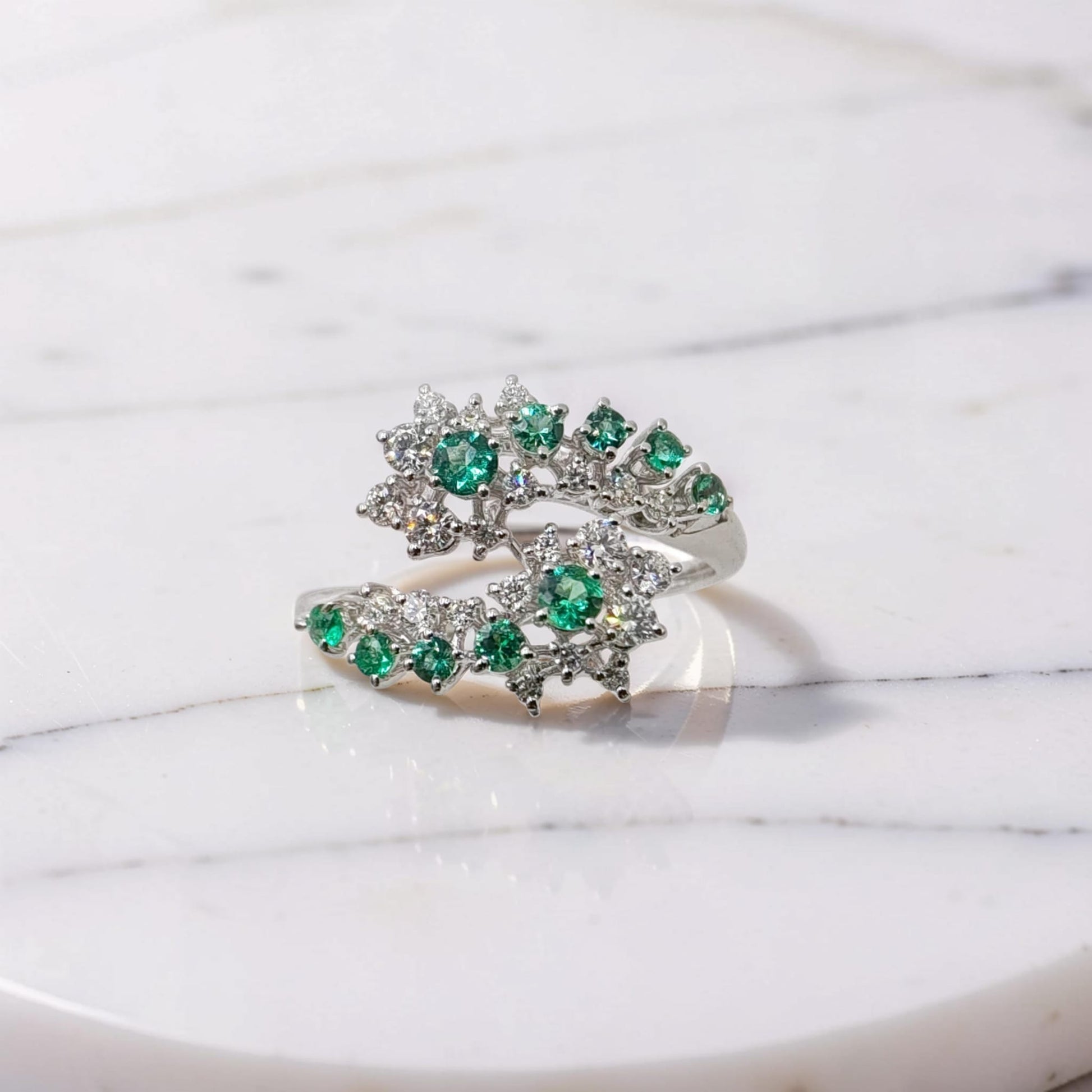 Anello oro bianco 18kt Meteore Gioielli a due teste di serpente con smeraldi naturali e diamanti naturali 0,39 ct su sfondo bianco marmoreo