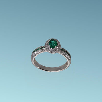 anello di meteore gioielli con smeraldo ovale centrale contornati da diamanti. Sui lati dell'anello ci sono tre binari di diamanti e smeraldi