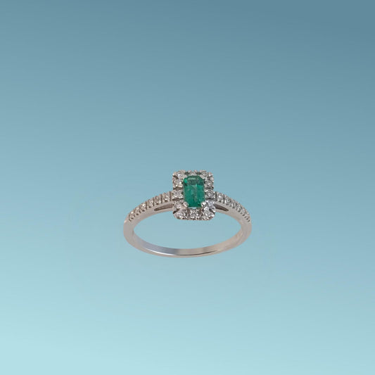 Anello in oro bianco 18kt di Meteore Gioielli presenta uno Smeraldo centrale taglio rettangolare da 0.29 ct e il contorno di diamanti naturali di ct 0.19 G/VS