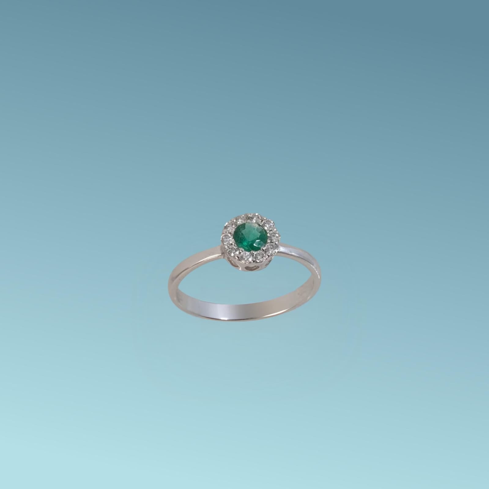 Anello in oro bianco 18kt di Meteore Gioielli con Smeraldo centrale tondo taglio brillante ct 0.20 con contorno di diamanti naturali taglio brillante ct 0.16
