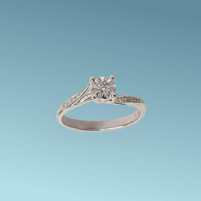 Anello Solitario di Mirco Visconti è  realizzato in oro bianco 18 carati; Il design raffinato presenta una montatura con due fasce impreziosite da piccoli diamanti che si uniscono per sostenere un diamante centrale ct 0.07 e diamanti intorno ct 0.12 G/VS, su un castone tipo "Magic"