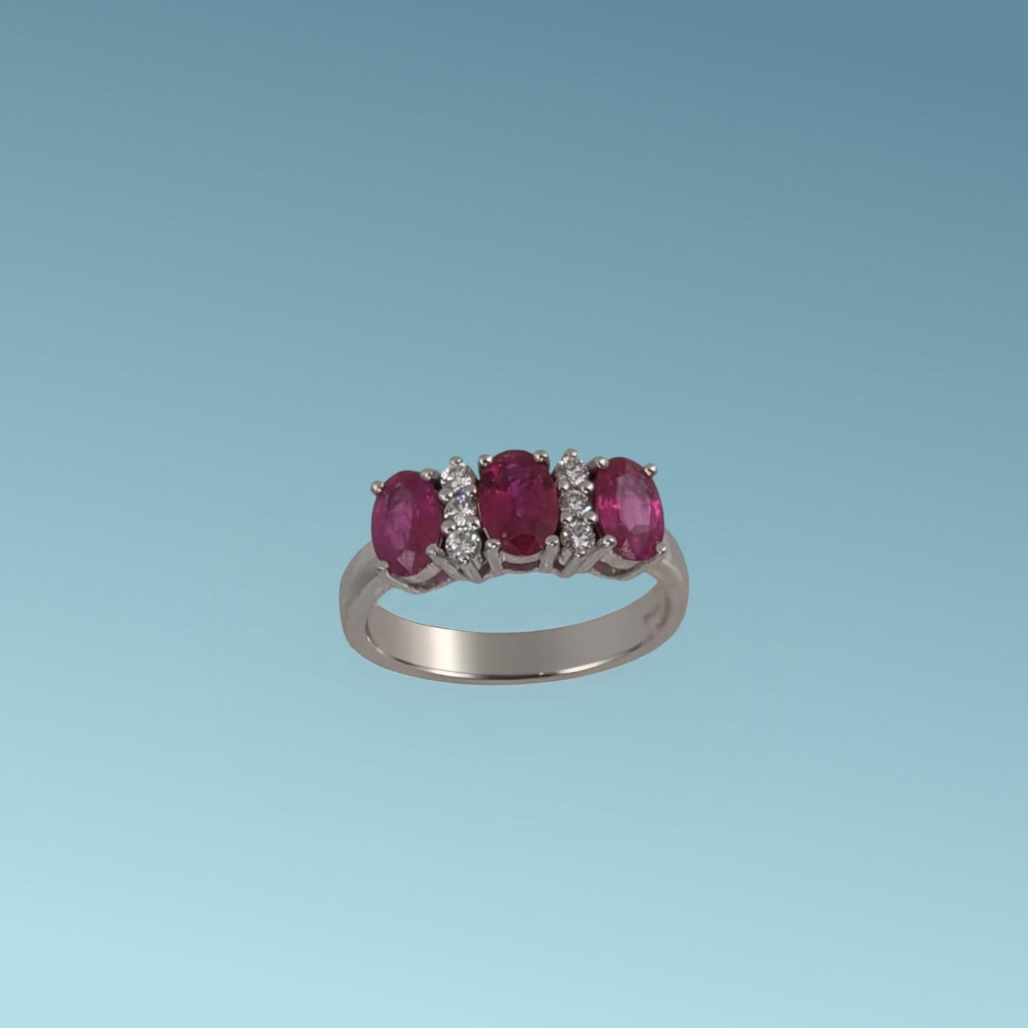 'anello di rubini in oro bianco 18kt di mirco visconti si distingue per l'alternanza armonica dei tre rubini naturali ovali per un totale di 1.37 carati e i&nbsp;luminosi diamanti naturali taglio brillante di 0.12  ct incassati tra loro