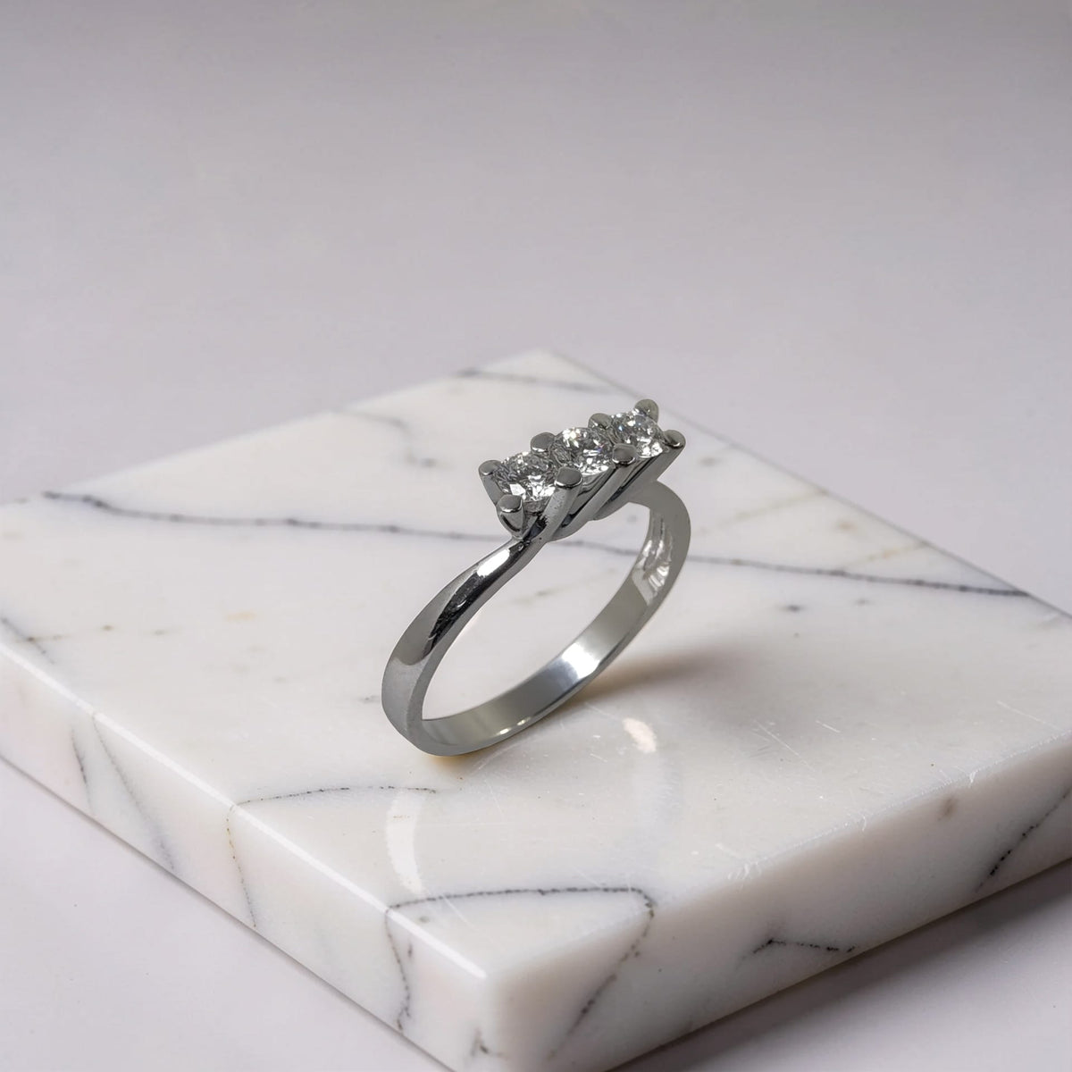 Dettaglio dei tre diamanti di un anello trilogy in oro bianco 18kt da 0,38 ct