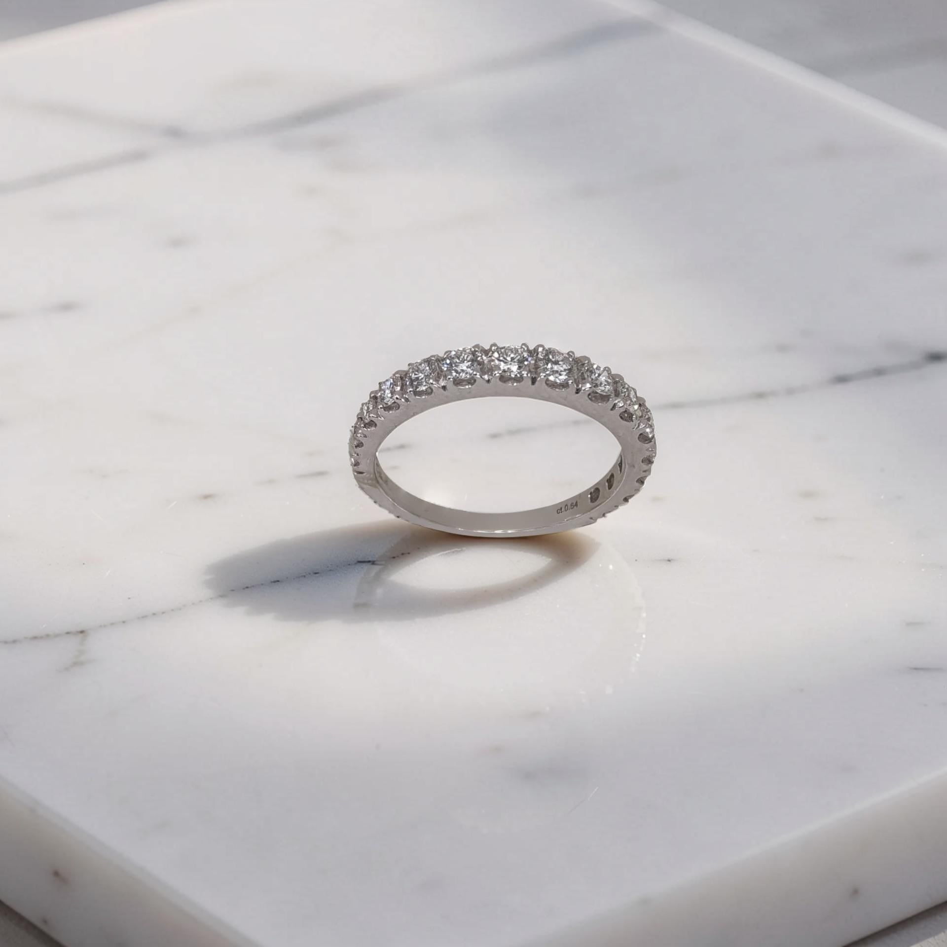 Anello veretta in oro bianco 18kt di Mirco Visconti con 15 Diamanti naturali taglio brillante a scalare che ricoprono 3/4 di superfice della montatura dell'anello. 