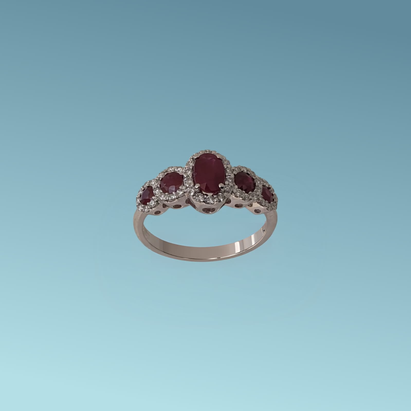 Anello con rubini in oro bianco 18kt di meteore Gioielli, tipo veretta a scalare. Ha un rubino centrale ct 0.74 e ai lati 4 rubini taglio brillante a scalare per un totale di ct 0.49 e diamanti naturali,  taglio brillante per un totale di 0.27 ct